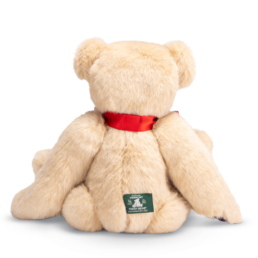 15-inch cream-colored plush bear with soft fur, red satin ribbon collar, and green fabric tag on back.