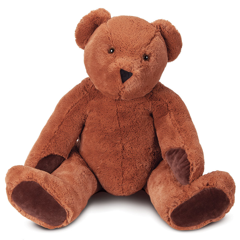 Large brown plush teddy bear with dark brown paw pads and a stitched nose, sitting upright.