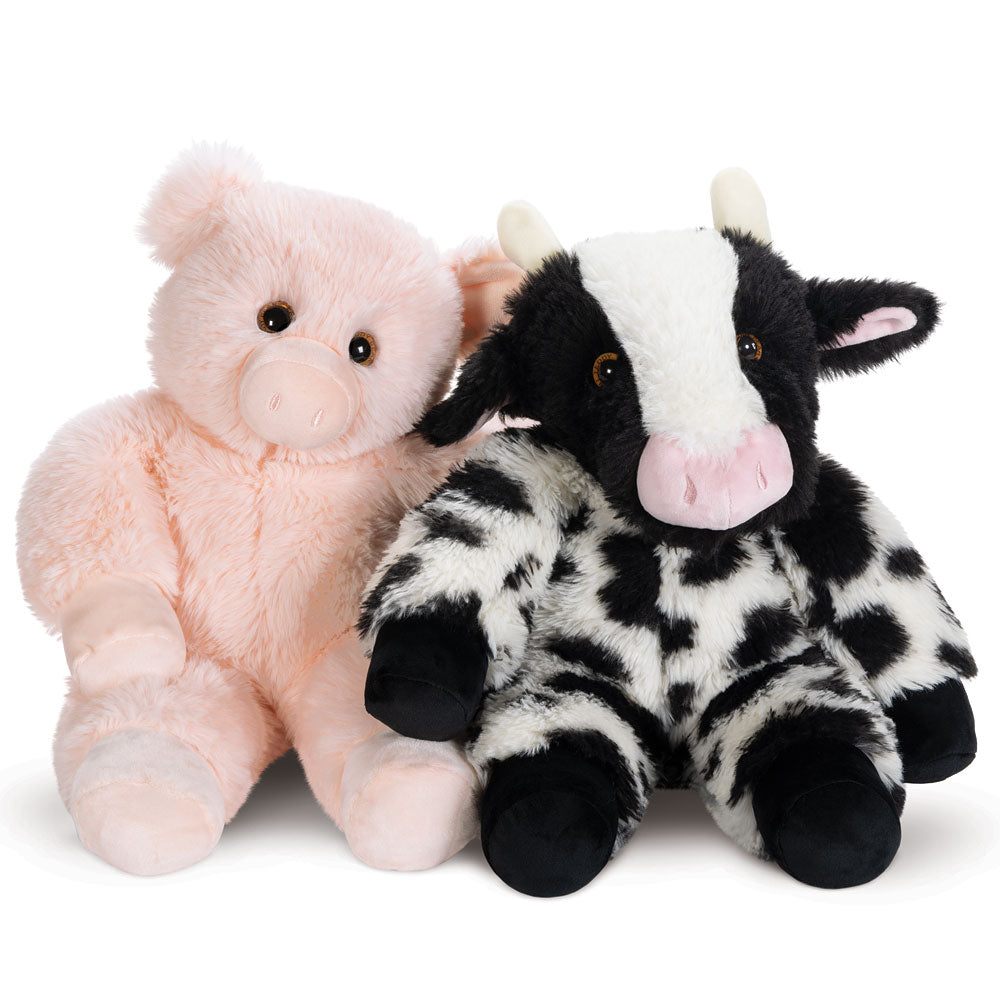 Soft pink plush pig and black-and-white spotted plush cow sitting side by side.
