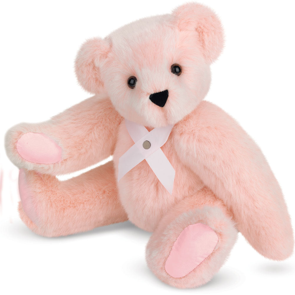 Soft pink plush bear with brown eyes and pink paw pads wearing a pink breast cancer awareness ribbon.