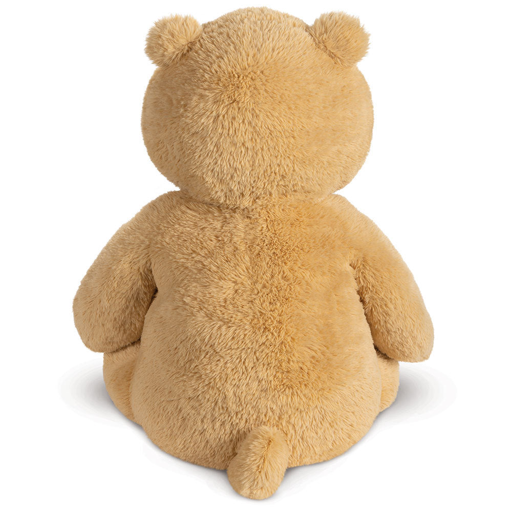 Plush light brown teddy bear sitting with back facing forward and small tail visible.