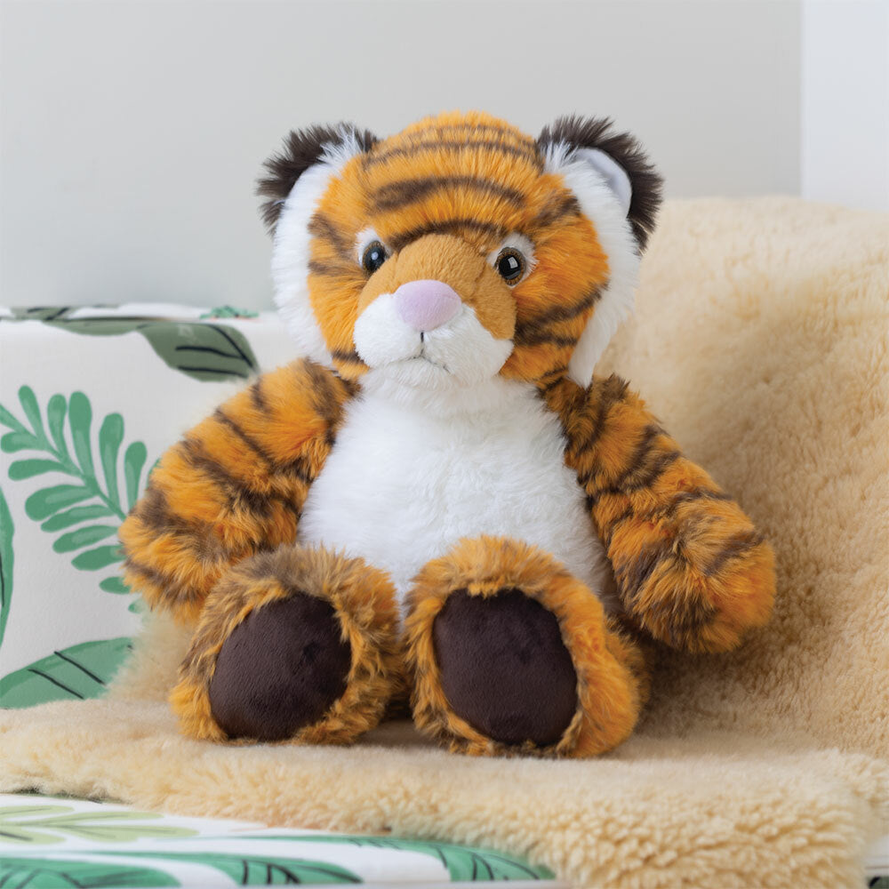 Plush tiger stuffed animal with orange and black stripes, white belly, and dark paws seated on beige blanket.