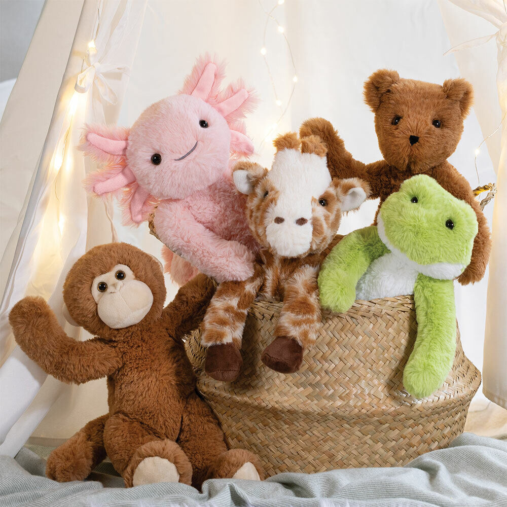 Green plush frog with white belly and big eyes sitting in a woven basket with other stuffed animals.
