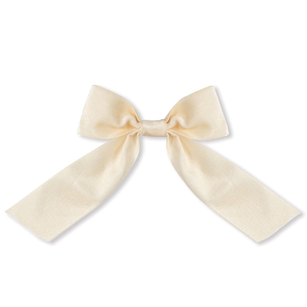 Ivory velvet bow with long tails, soft texture, elegant decorative knot.