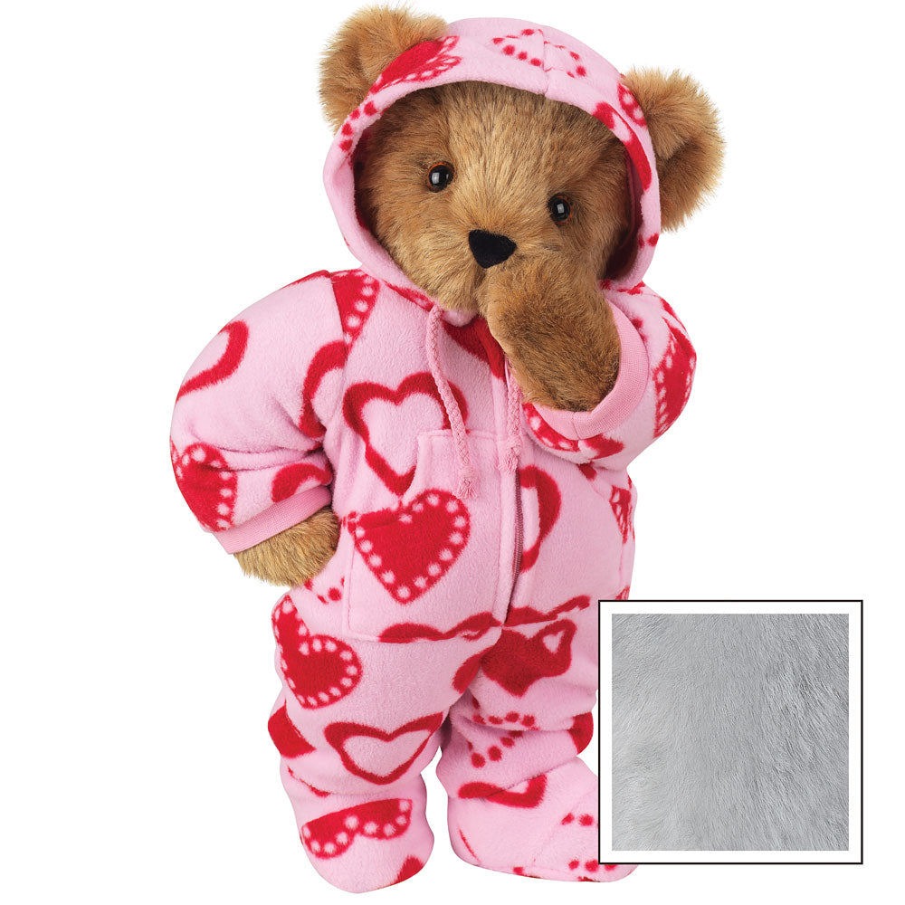 Brown teddy bear wearing pink hoodie-footie suit with red heart patterns and front zipper.