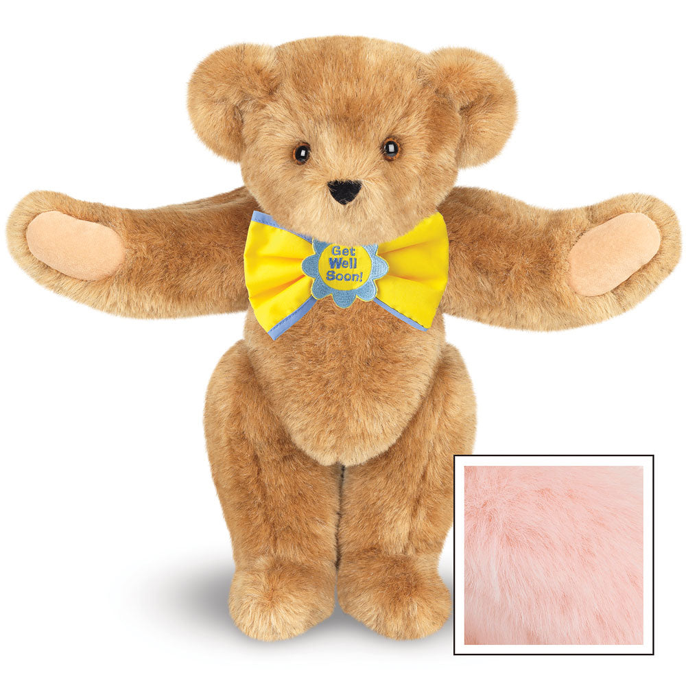 Honey-colored teddy bear with outstretched arms wearing a bright yellow bow tie with "Get Well Soon" text and brown eyes.