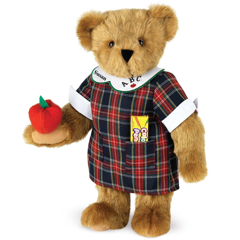 Brown teddy bear wearing a plaid teacher dress with ABC collar and holding a red apple.