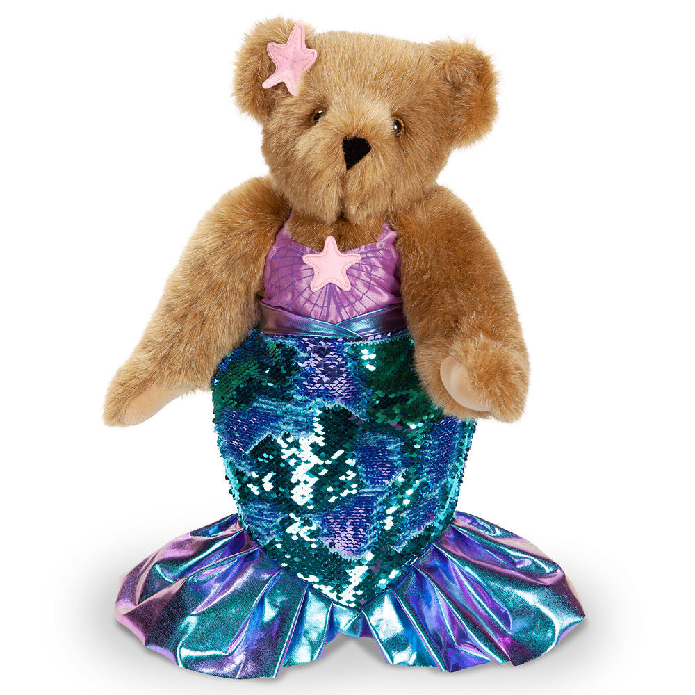 Honey-colored plush bear with purple star clip, purple top, and shiny blue-green sequin mermaid tail.