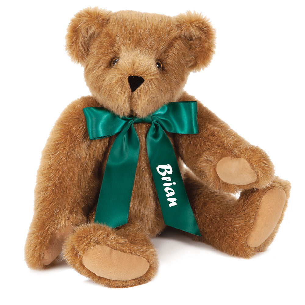 Light brown plush teddy bear with a green satin bow and "Brian" embroidered on the ribbon.