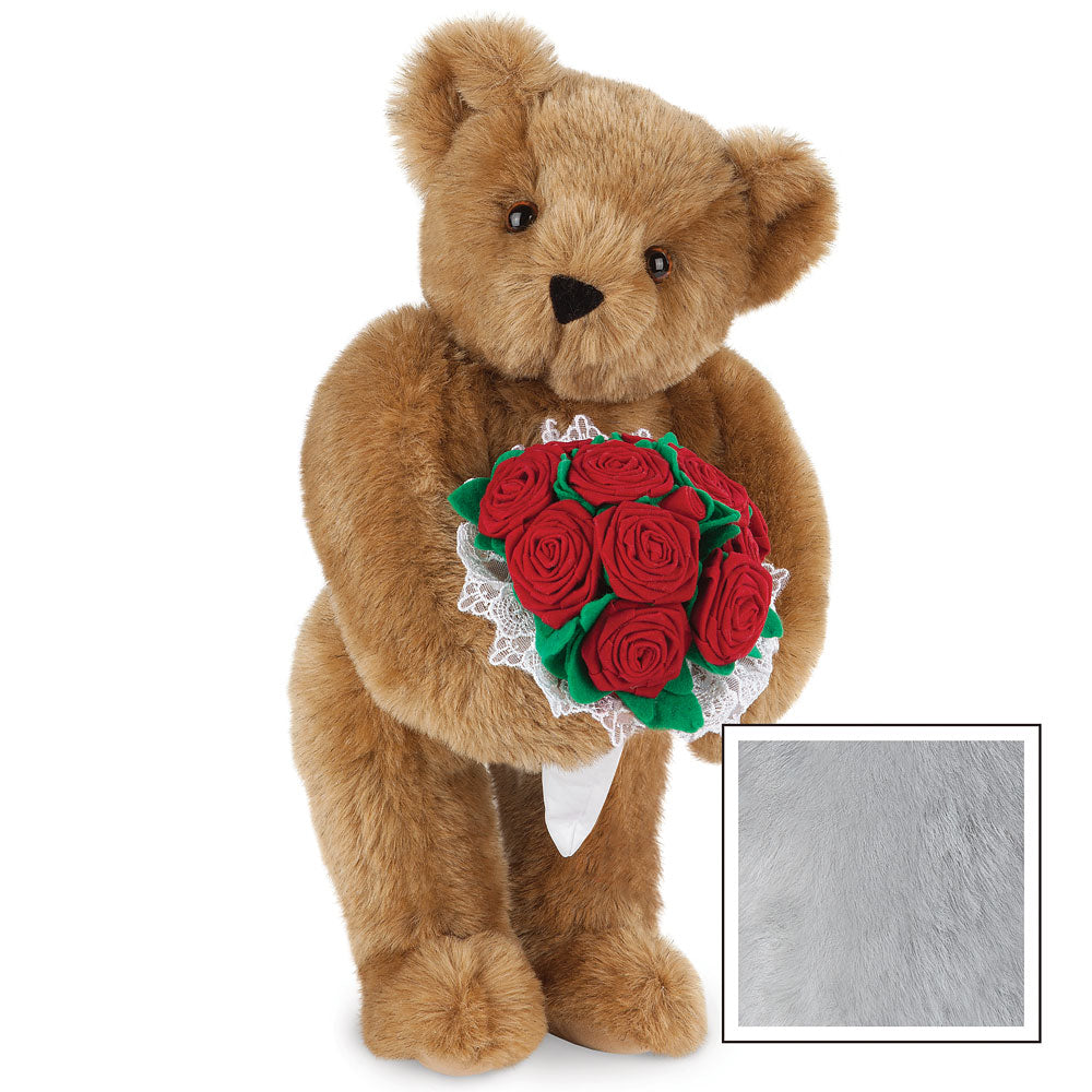 Honey-colored teddy bear holding a bouquet of red roses with white lace trim.