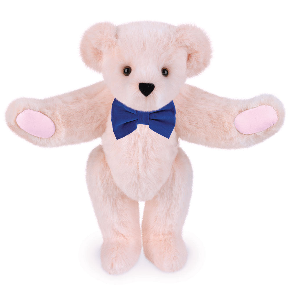 Soft bubblegum pink plush bear with brown eyes and a royal blue bow tie.