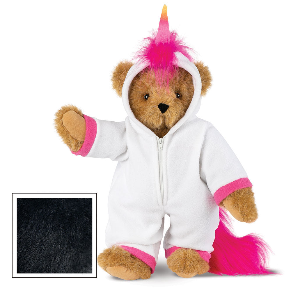 Brown teddy bear wearing white unicorn hoodie with pink cuffs, hood horn, and tail tuft, standing upright.
