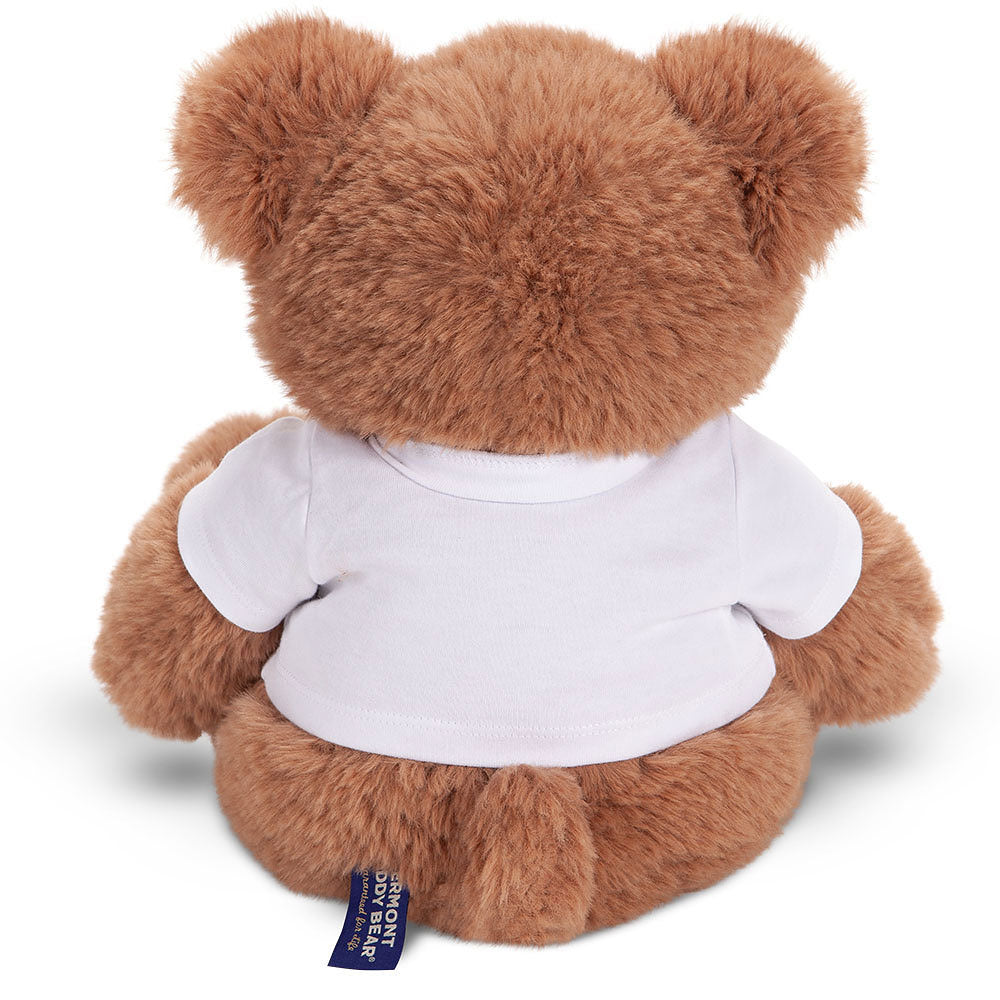 Brown teddy bear wearing a plain white t-shirt, sitting facing away.