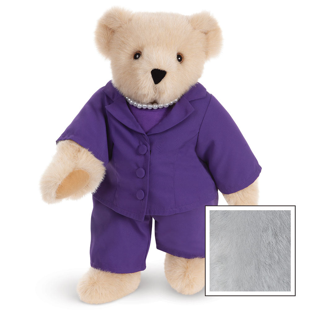 Honey-colored teddy bear wearing a purple business suit with matching pants and buttons.