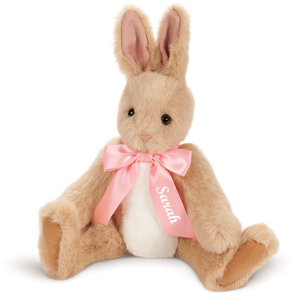 Soft tan and white plush bunny with pink satin bow and "Scratch" printed on ribbon around neck.