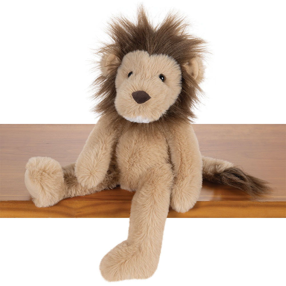 Soft tan plush lion with dark brown mane and tail tuft seated on wooden surface.