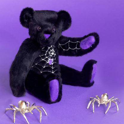 Black teddy bear with spider web design and purple nose and paws, perfect for Halloween decorating