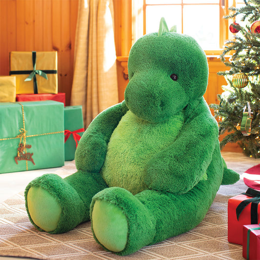Green dinosaur plush toy in a festive room with Christmas tree and presents