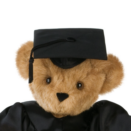 Brown teddy bear wearing a black graduation cap with a tassel and black gown.