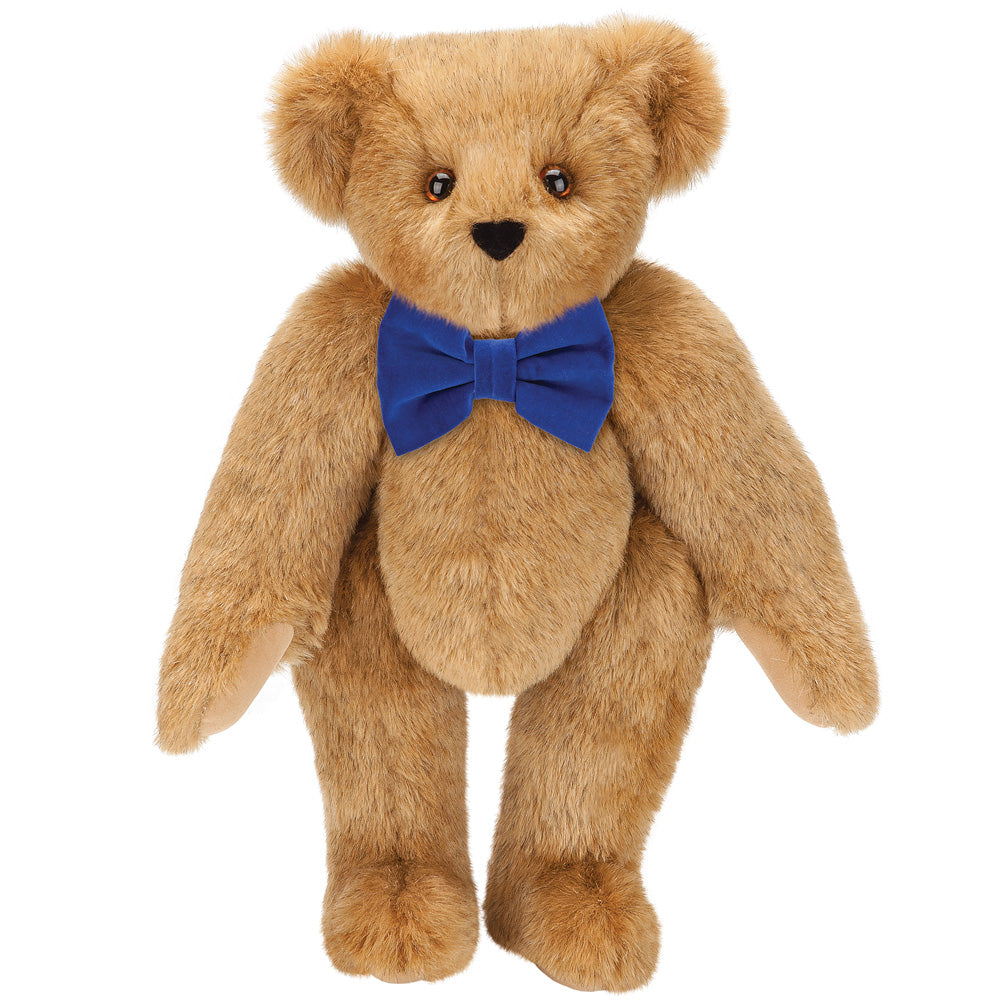 Honey-colored plush teddy bear with brown eyes and royal blue bow tie.